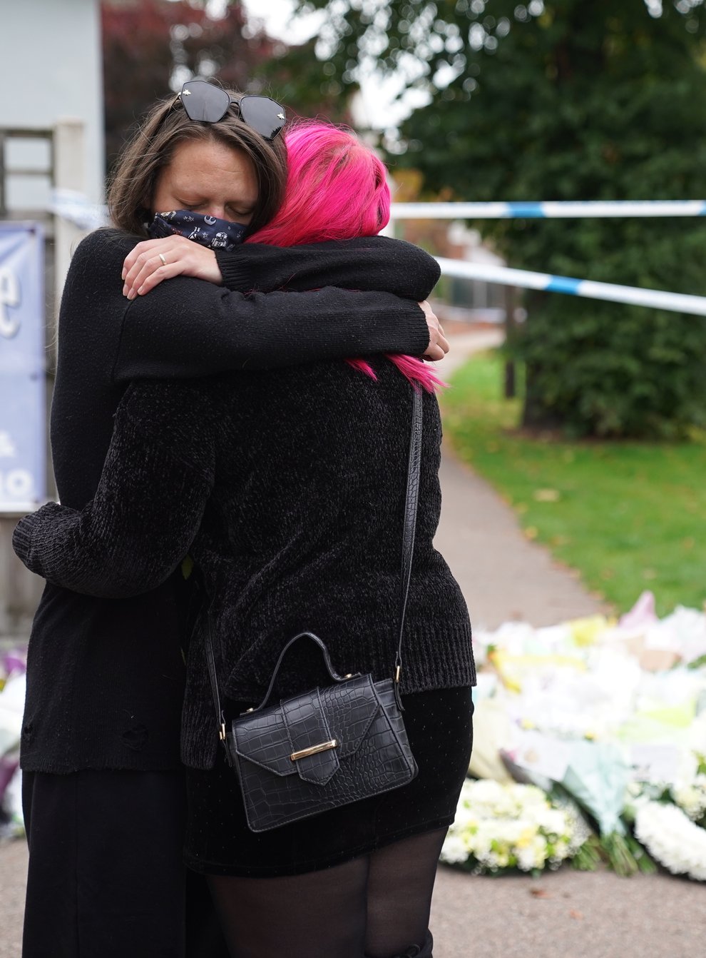 People hug at the scene near Belfairs Methodist Church in Leigh-on-Sea, Essex, where Conservative MP Sir David Amess was killed (Kirsty O’Connor/PA)