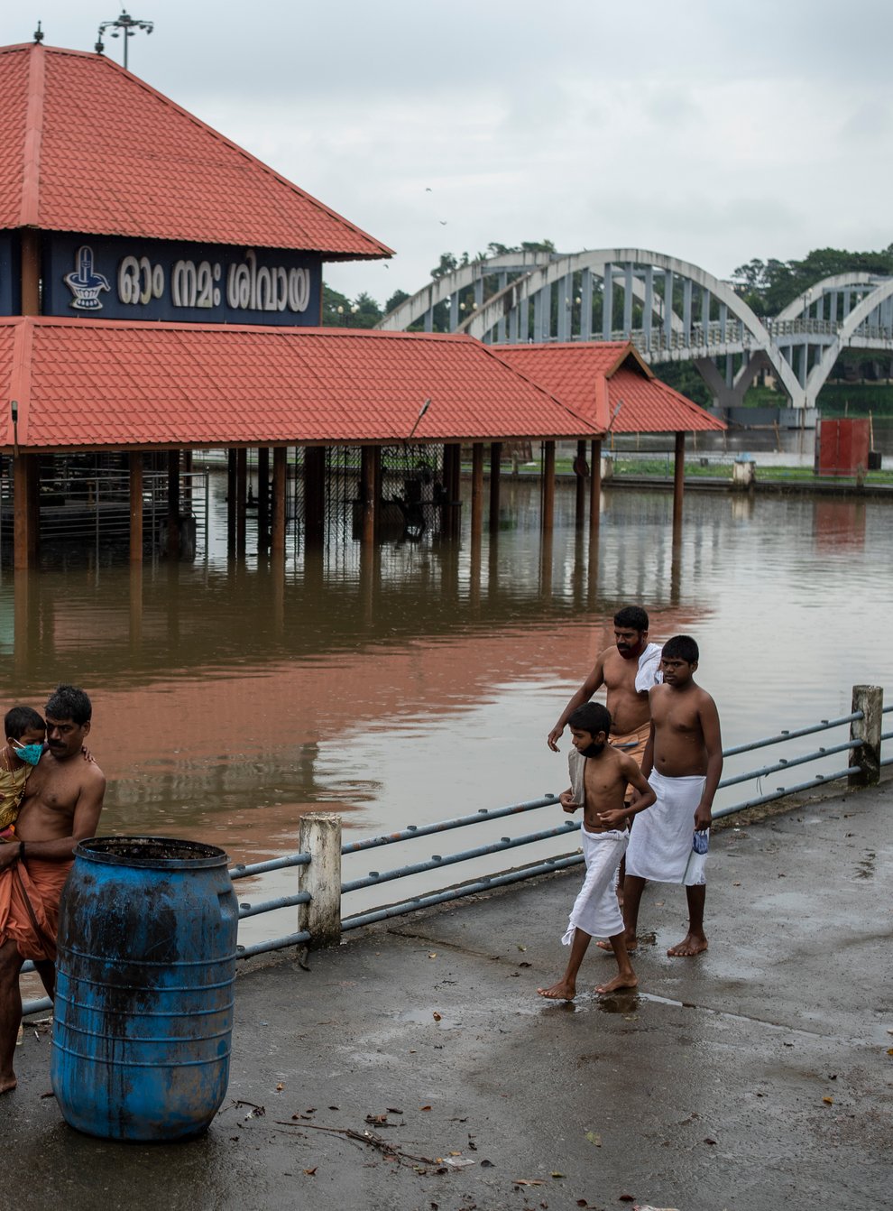 Hindu devotees walk back after performing rituals, past an inundated Shiva temple on the banks of the Periyar River following heavy rains in Kochi, Kerala state, India, Tuesday, Oct. 12, 2021. (AP Photo/R S Iyer)