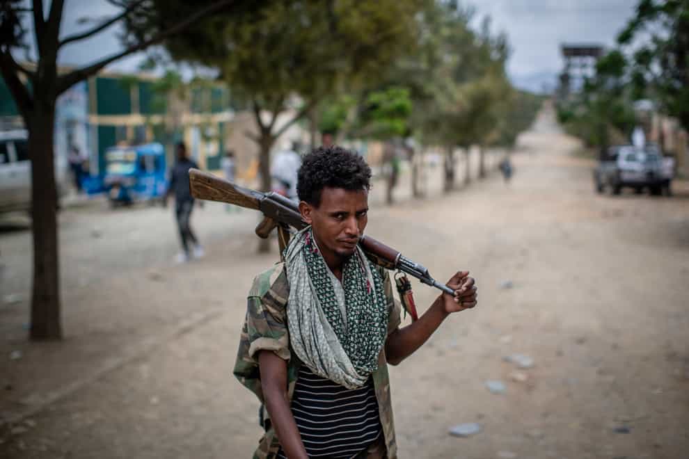A fighter loyal to the Tigray People’s Liberation Front (TPLF) walks along a street (Ben Curtis/PA)