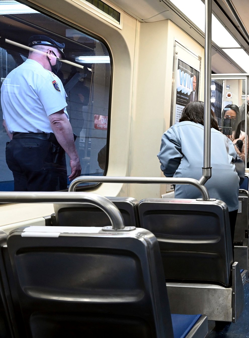 Septa Transit Police Chief Thomas Nestel III, seen through window at left, stands by following a news conference on an El platform (Tom Gralish/AP)