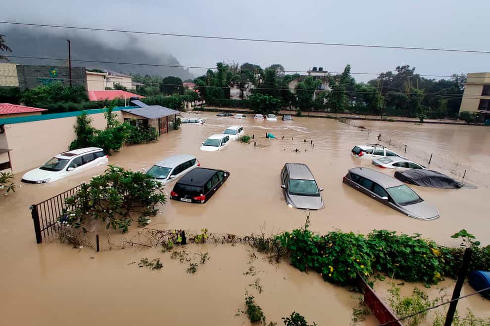 Submerged cars at a flooded hotel resort as extreme rainfall caused the Kosi River to overflow at the Jim Corbett National Park in Uttarakhand, India (Mustafa Quraishi/AP)