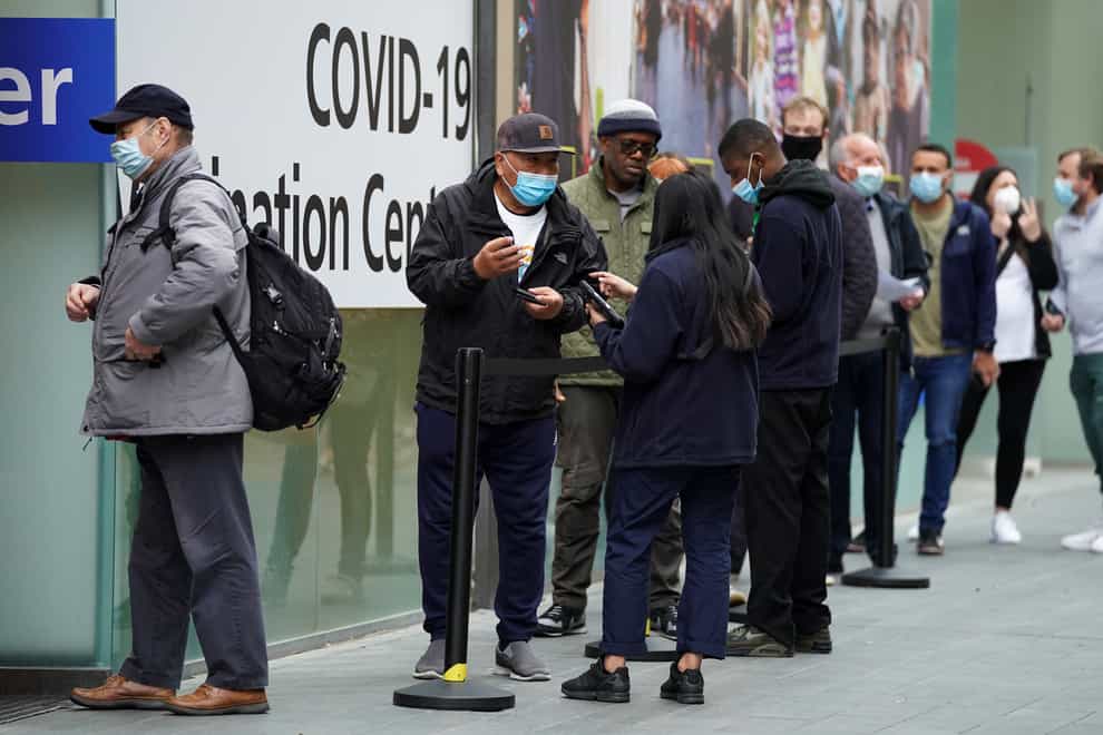 People queue to receive a Covid-19 jab at a pop-up vaccination centre at Westfield Stratford City shopping centre in east London (Kirsty O’Connor/PA)
