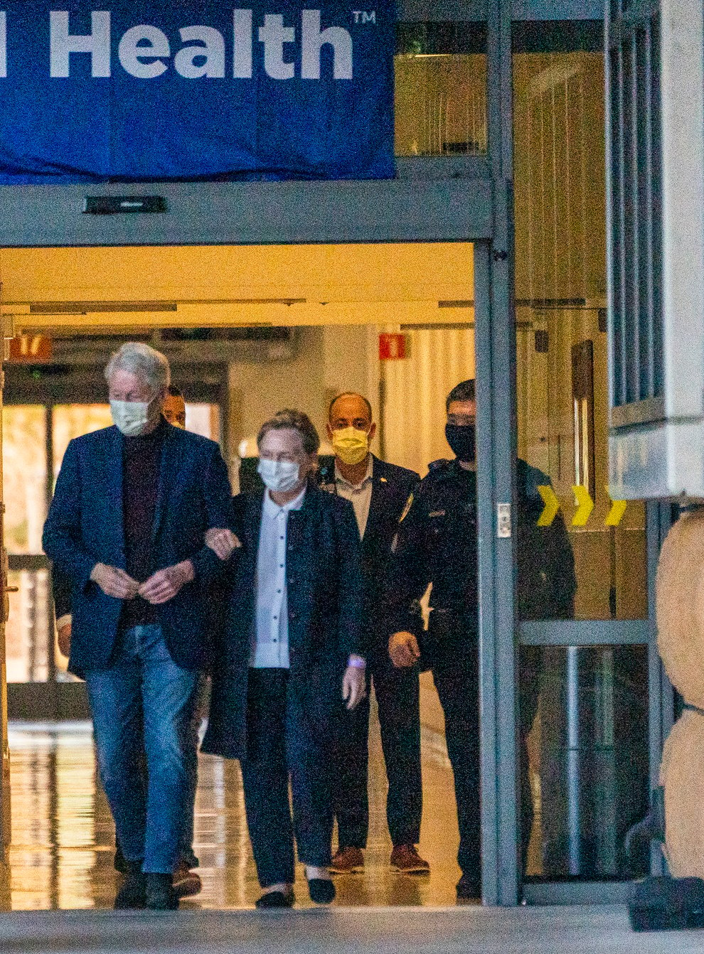 Bill Clinton leaving hospital with his wife Hillary (Damian Dovarganes/AP)