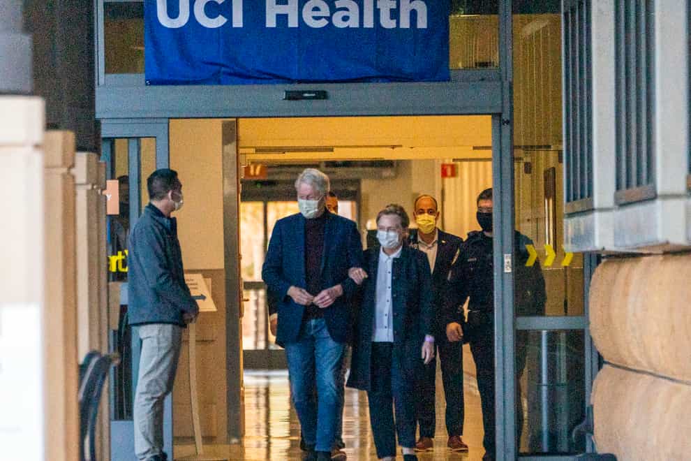 Bill Clinton leaving hospital with his wife Hillary (Damian Dovarganes/AP)