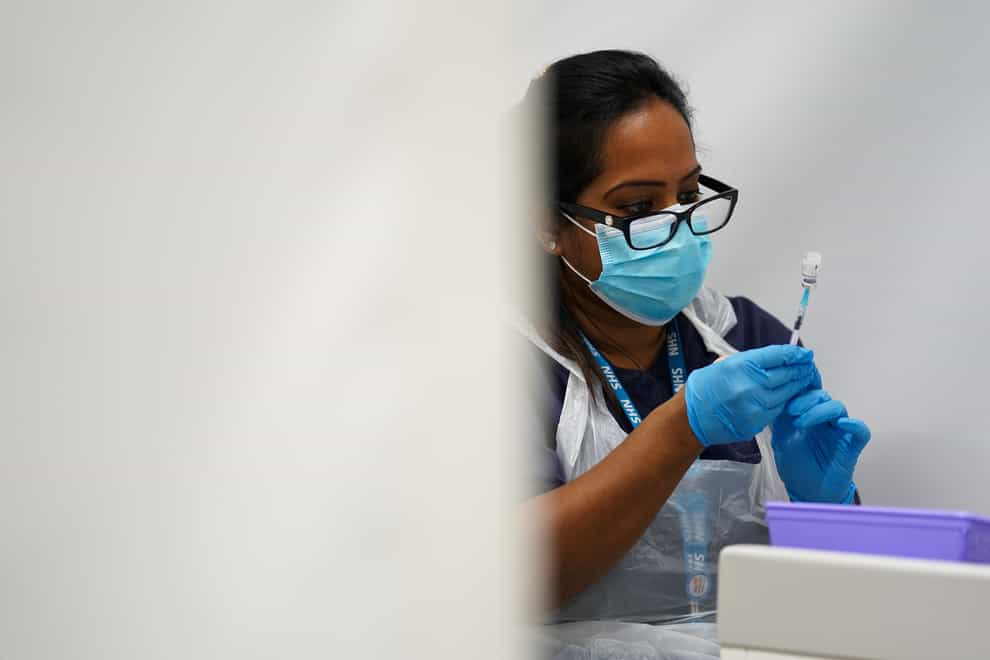 A member of staff prepares a Covid-19 Pfizer jab at a pop-up vaccination centre at Westfield Stratford City shopping centre in east London (Kirsty O’Connor/PA)