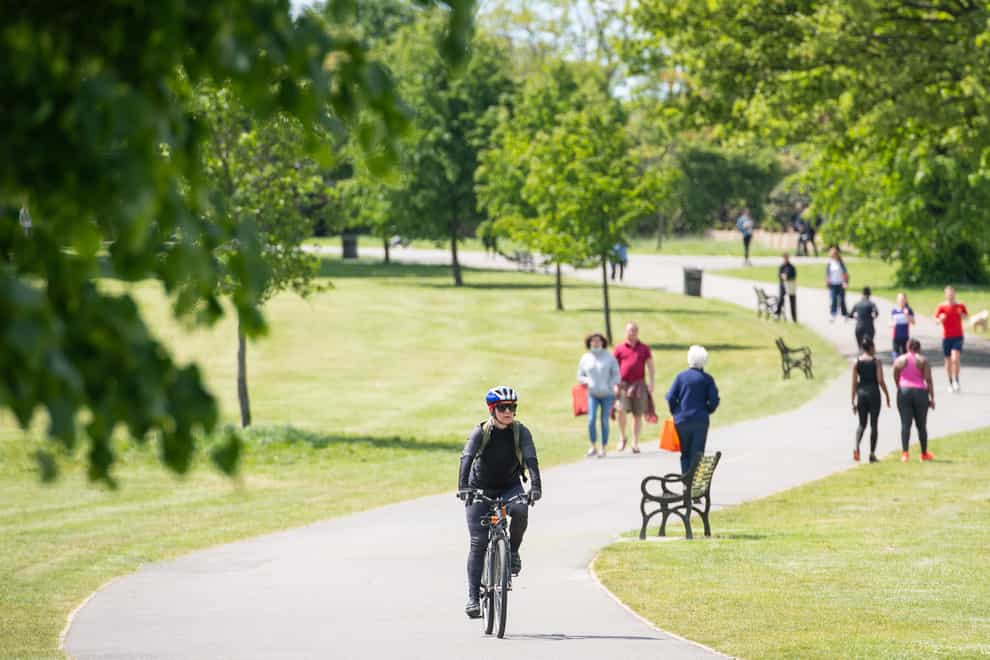 People walk and exercise in the sun in Brockwell Park, south London (Dominic Lipinski/PA)