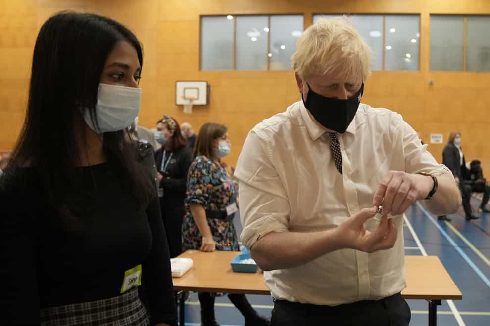 Prime Minister Boris Johnson shakes a dose of the pfizer vaccine (Matt Dunham/PA)