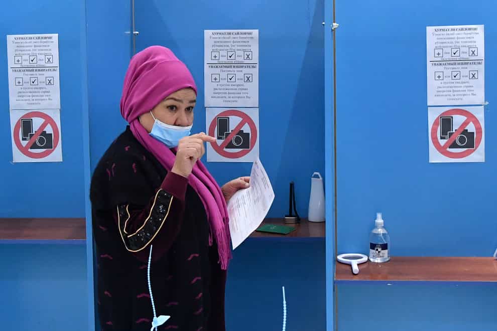 A woman casts her vote at a polling station during the presidential election in Tashkent, Uzbekistan (AP)