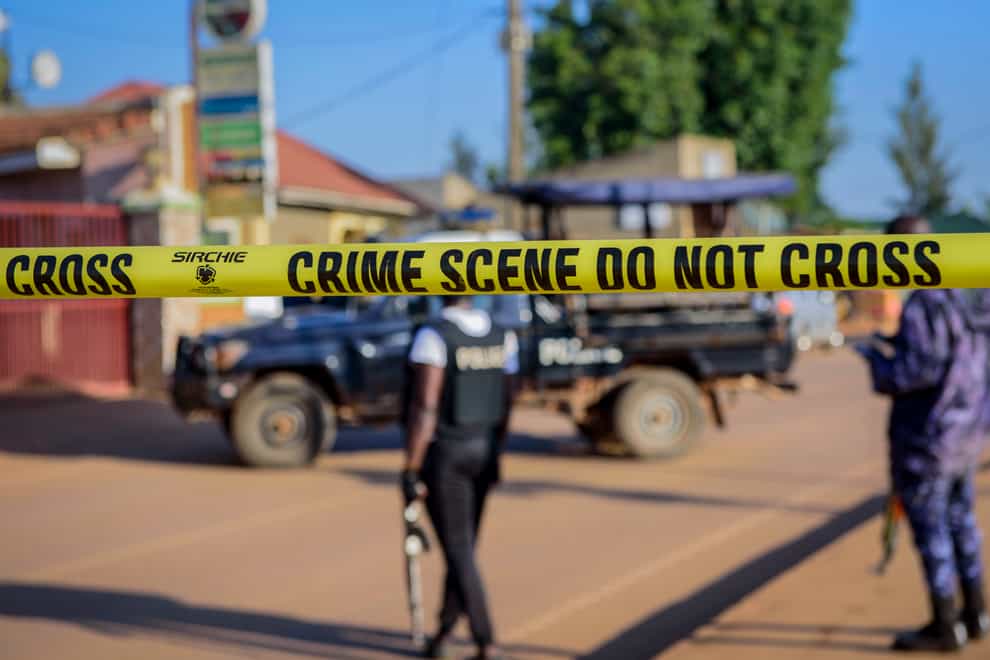 Ugandan police secure a road leading to the scene of an explosion in the Komamboga suburb of the capital, Kampala, (Nicholas Bamulanzeki/AP)