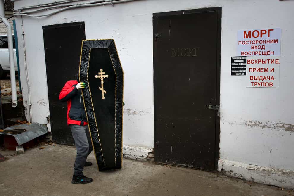 A funeral worker carries a coffin cover for a patient who died of Covid-19 at Infectious Hospital No 5 in Nizhny Novgorod, Russia (Roman Yarovitcyn/AP)