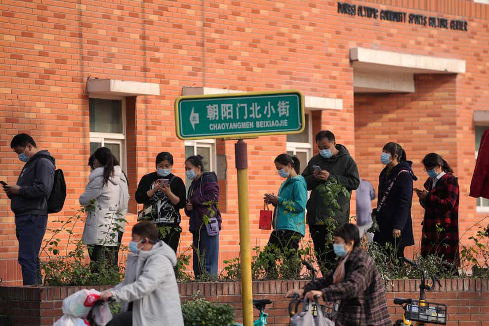 Residents line up to receive booster shots against Covid-19 at a vaccination site in Beijing (Andy Wong/AP)