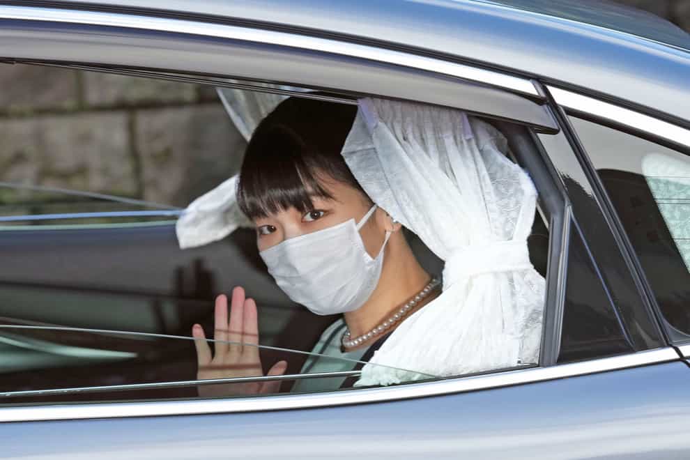 Japan’s Princess Mako waves from a car as she leaves her home in Akasaka Estate in Tokyo (Chika Oshima/Kyodo News via AP)