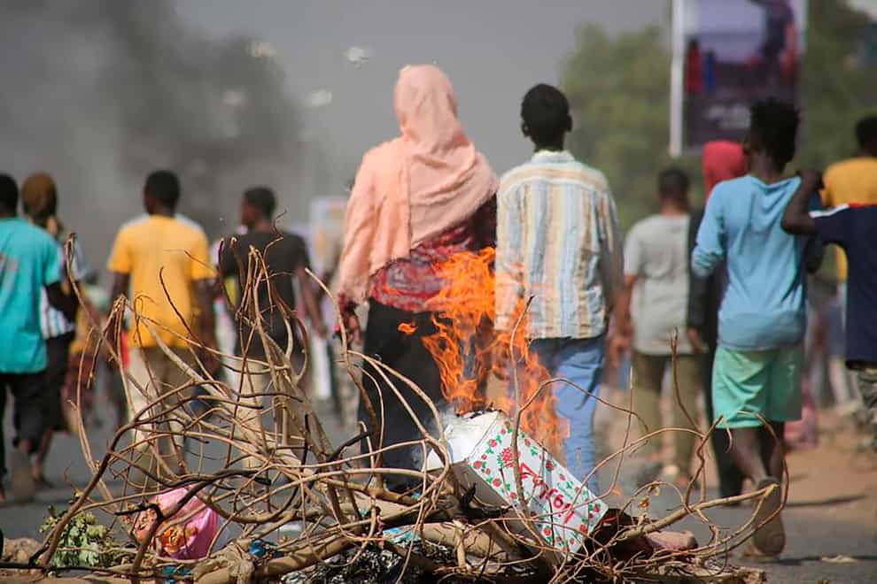 Pro-democracy protesters use fires to block streets to condemn a takeover by military officials in Khartoum, Sudan (Ashraf Idris/AP)