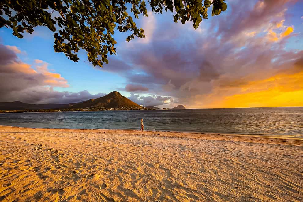 The sun sets over the Tamarin Mountain as seen from the beach at the village of Flic-en-Flac (Ben Birchall/PA Wire)