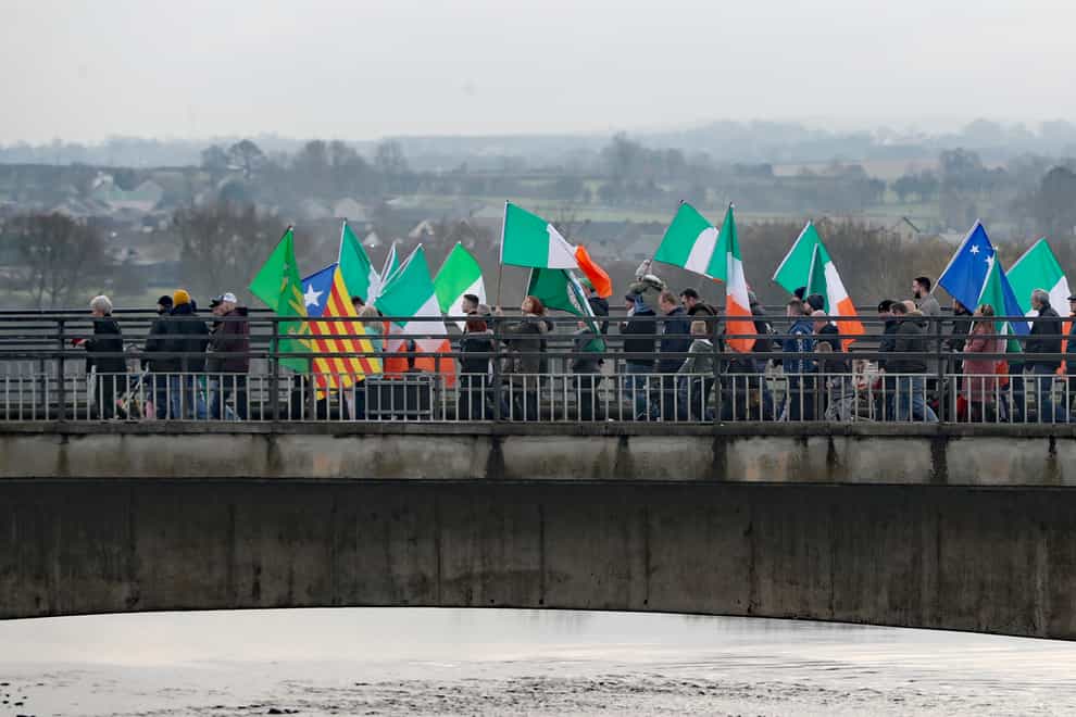 People take part in an Irish unity march as they cross the Lifford Bridge, from Donegal, which marks the border between Strabane in County Tyrone, Northern Ireland, and Lifford in County Donegal in the Republic of Ireland (Niall Carson/PA)
