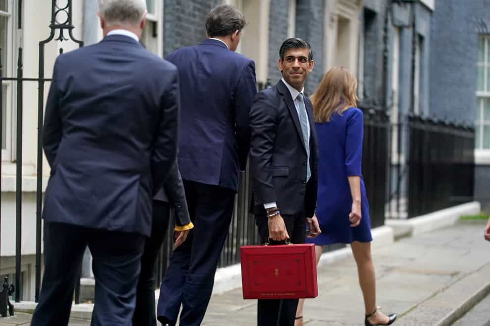 Chancellor Rishi Sunak holds his ministerial ‘Red Box’ as he stands with his ministerial team and parliamentary private secretaries, outside 11 Downing Street (PA)