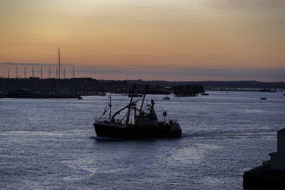 A fishing trawler leaves a harbour (PA)