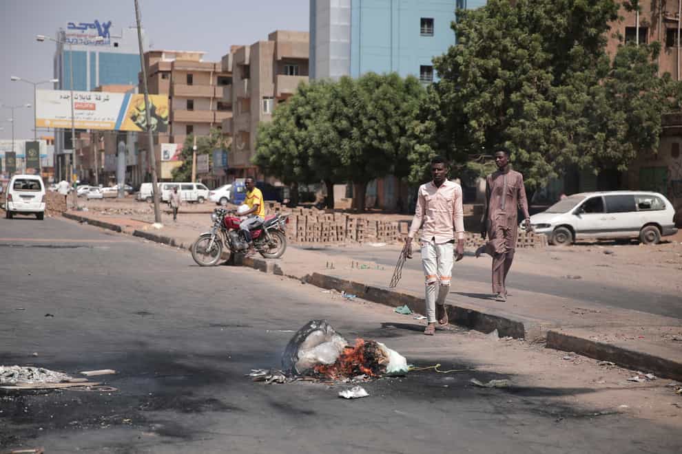 People walk on a street in Khartoum, Sudan, two days after a military coup (Marwan Ali/AP)