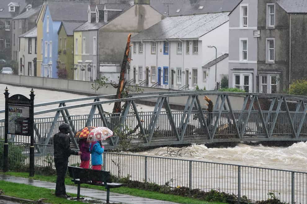 Residents watch rising water levels in Cockermouth (Owen Humphreys/PA)