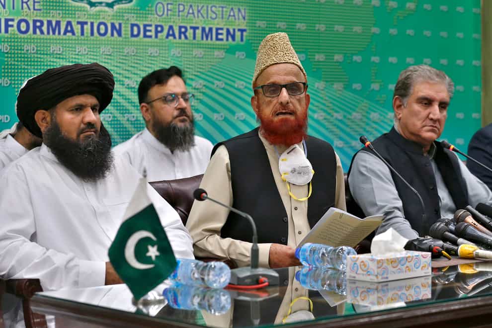 Pakistan’s foreign minister Shah Mahmood Qureshi, right, and top religious leader Mufti Muneebur Rehman, centre, who helped negotiate an end to a protest mach by Islamists (Anjum Naveed/AP)