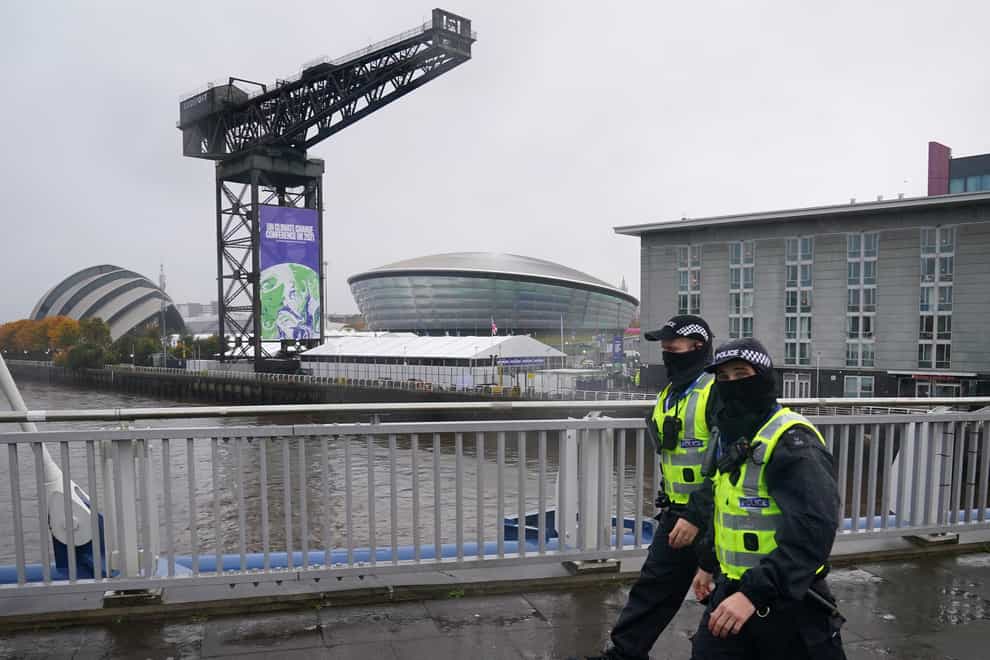 Police officers walk passed the Scottish Event Campus in Glasgow where Cop26 is being held (Andrew Milligan/PA)