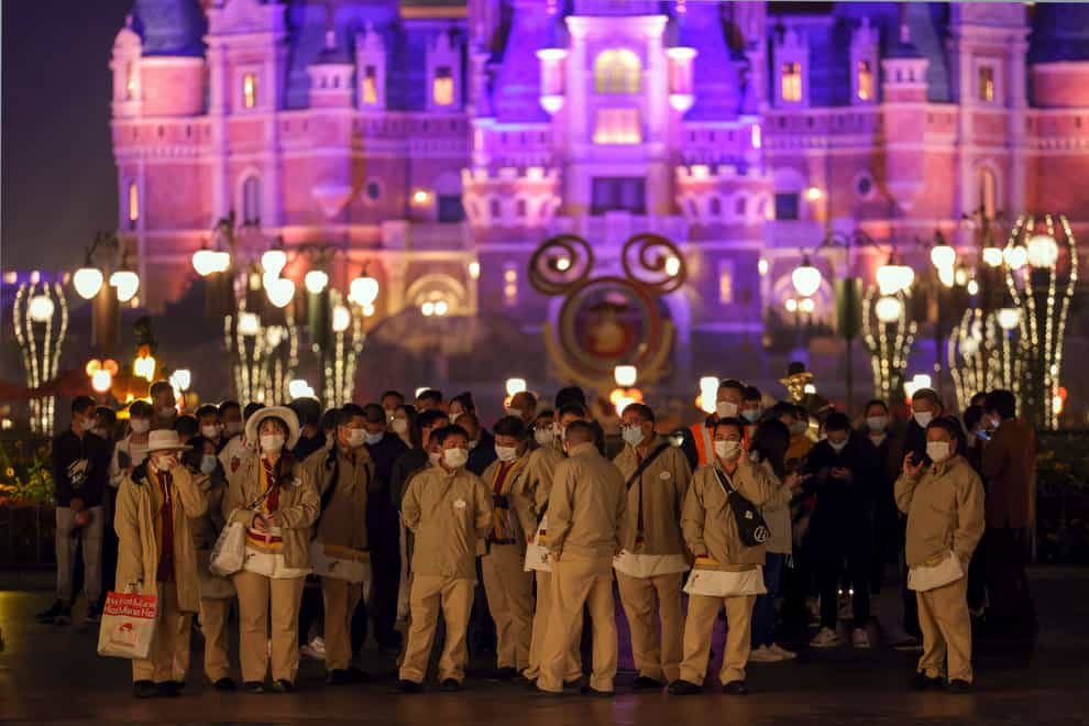 Disneyland employees gather to wait for their Covid-19 tests at Shanghai Disneyland in China (Chinatopix via AP)