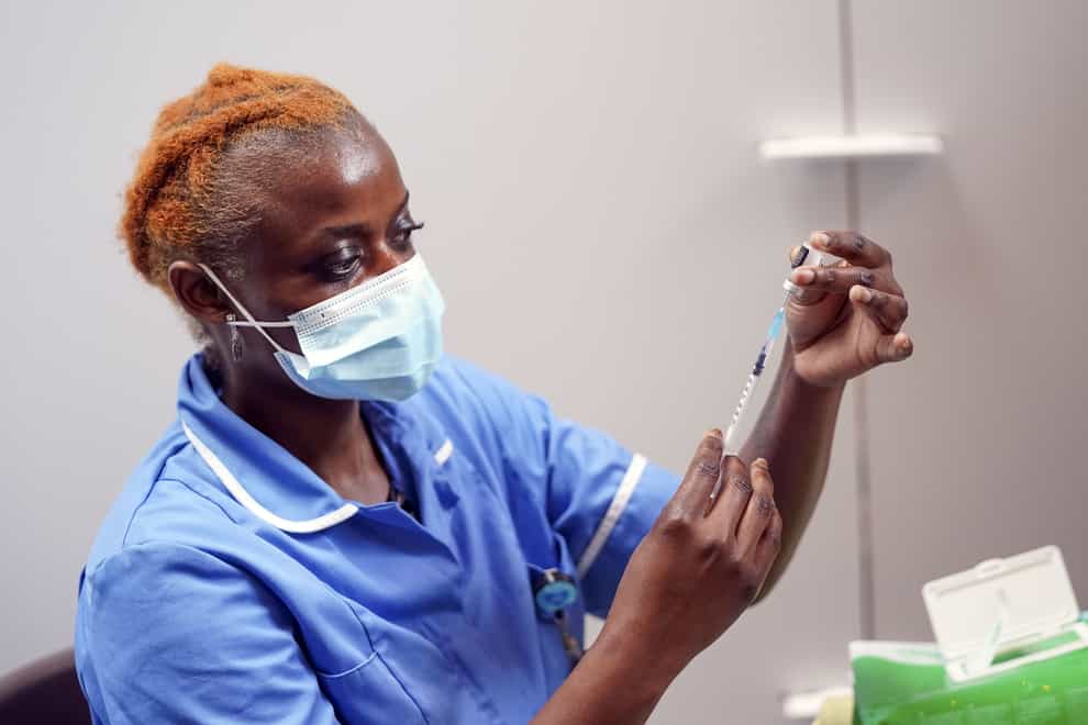 Nurse Marvis Birungi prepares to give a Covid-19 vaccine (Steve Parsons/PA)