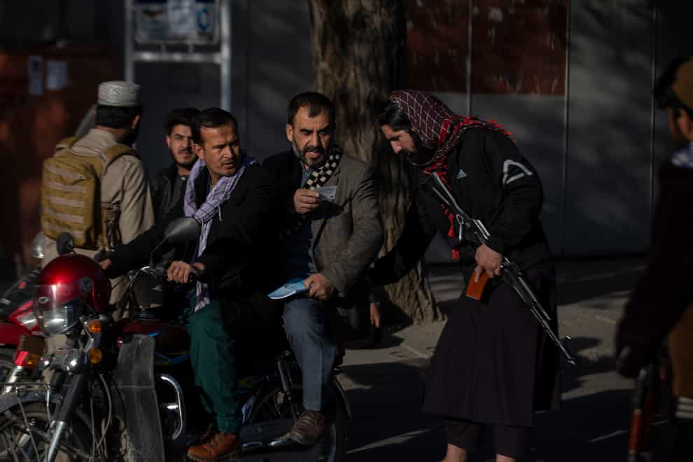 A Taliban fighter checks documents following an explosion in Kabul (Ahmad Halabisaz/AP)