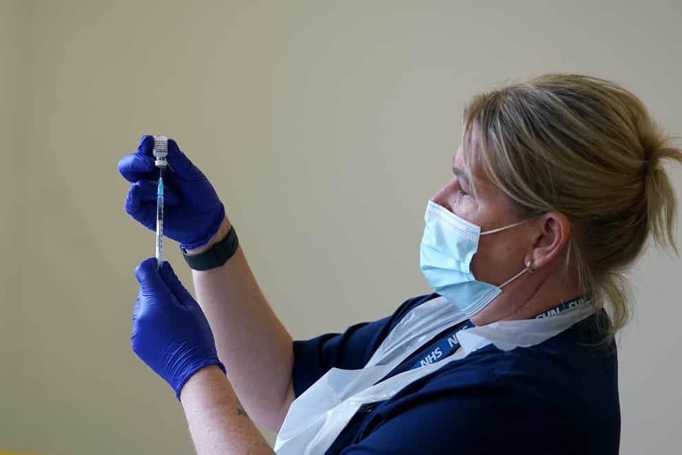 A nurse draws a syringe before administering a Covid-19 vaccine (Martin Rickett/PA)
