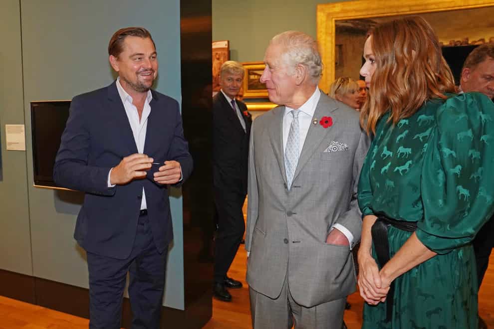 The Prince of Wales (centre) speaks with designer Stella McCartney (right) and Leonardo DiCaprio (left) as he views a fashion installation by the designer, at the Kelvingrove Art Gallery and Museum, during Cop26 (PA)