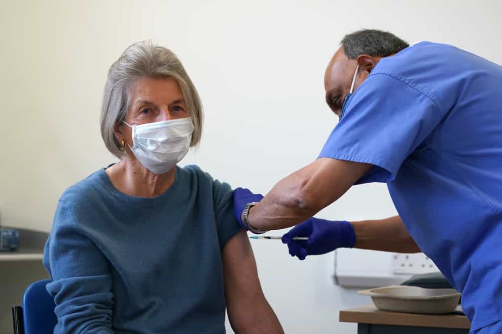 Doctor Abhi Mantgani administers a vaccine booster to Shirley Davies at Birkenhead Medical Building (Martin Rickett/PA)