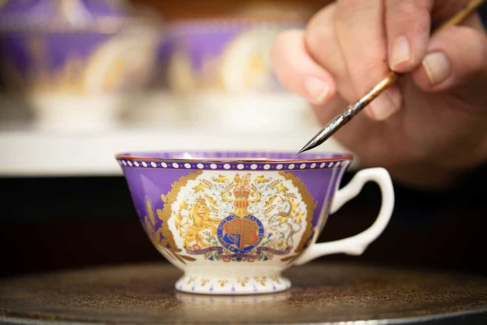 A teacup is hand-finished with 22-carat liquid gold before a finalfiring in the kiln (Royal Collection Trust/PA)