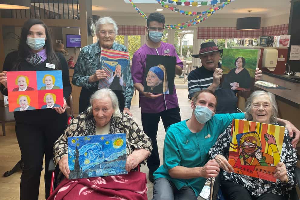 Residents and staff from Sandfields Care Home in Cheltenham pose with their artworks (Care UK/PA)