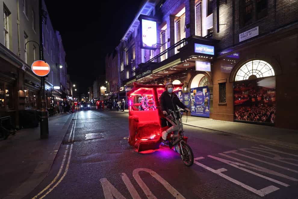 A pedal-powered rickshaw rides along Old Compton Street at closing time in Soho, central London (Yui Mok/PA)