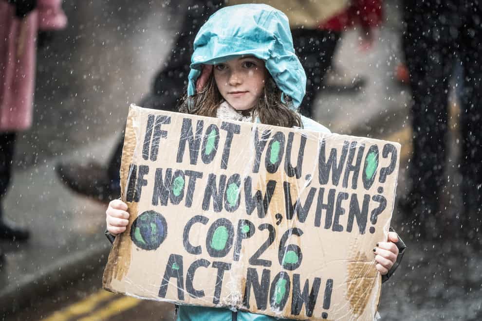 A protester holds up a sign on a climate rally in Glasgow (Jane Barlow/PA)