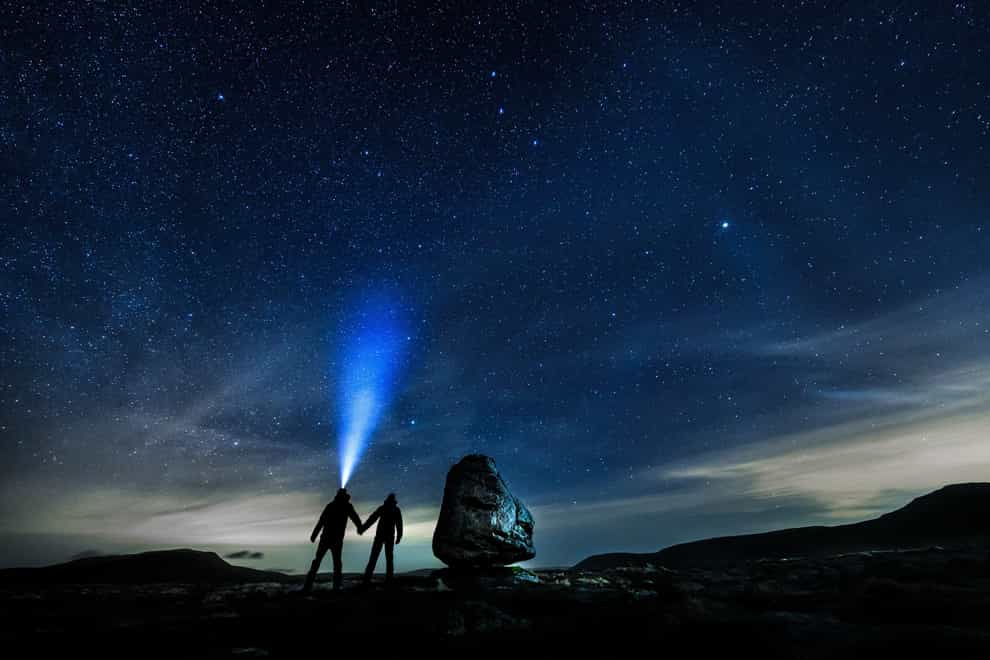 Walkers look up into the night sky (Danny Lawson/PA)