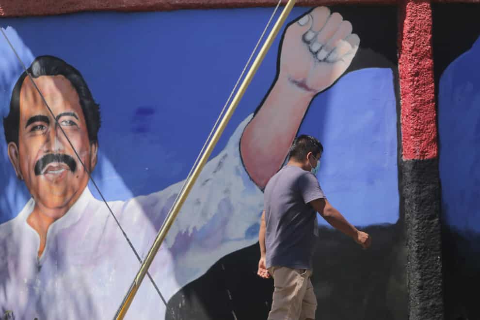 A man walks past a mural of Nicaraguan President Daniel Ortega (Andres Nunes/AP)