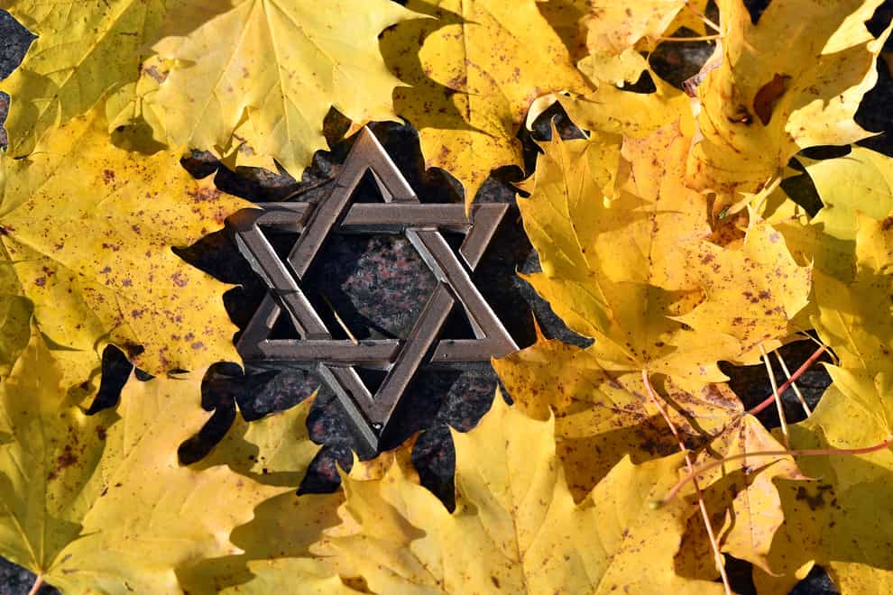 Autumn leaves lie on the gravestone with a small Star of David during a commemoration of the November pogroms in 1938 by the Jewish Regional Community at the Jewish Cemetery in Erfurt, Germany (Martin Schutt/AP)