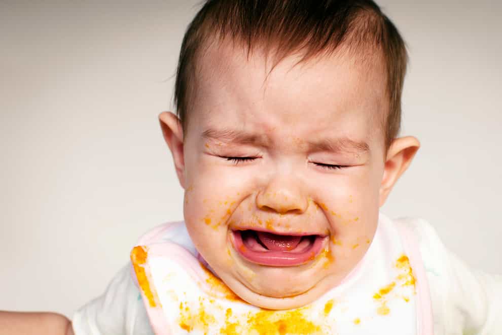 Baby crying during mealtime (Alamy/PA)
