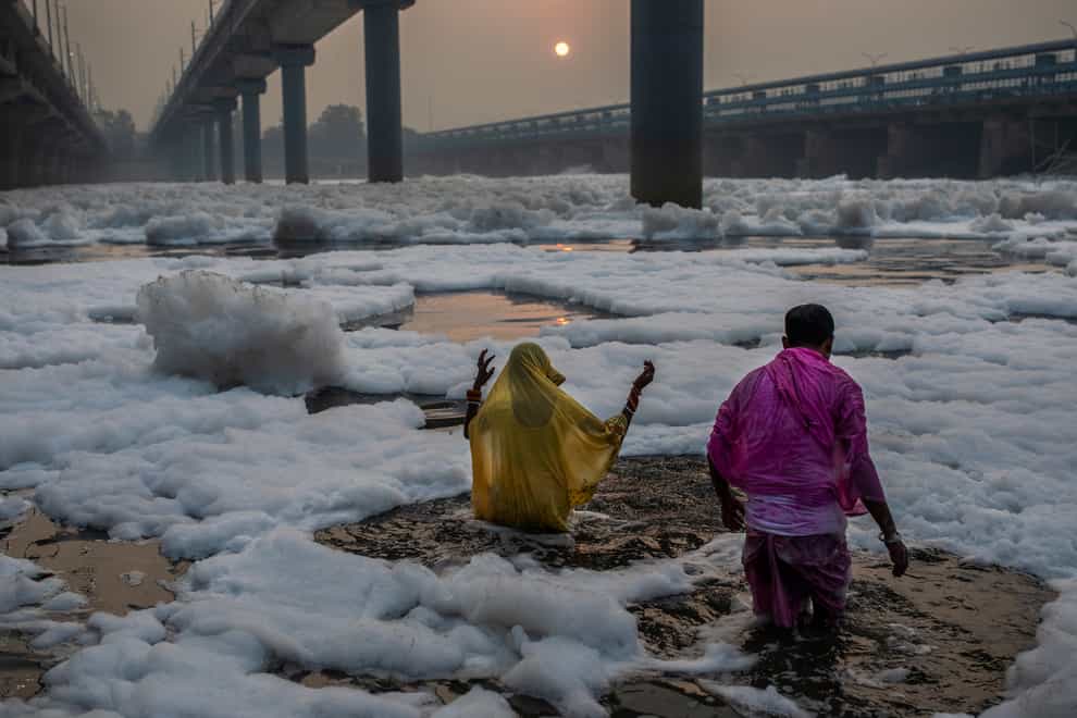 A vast stretch of one of India’s most sacred rivers, the Yamuna, is covered with toxic foam (Altaf Qadri/AP)