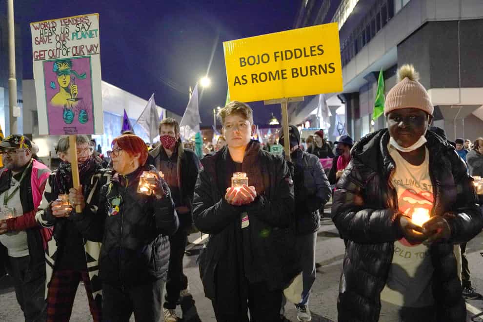 Climate protesters hold a candle lit protest outside the Cop26 summit (Andrew Milligan/PA)