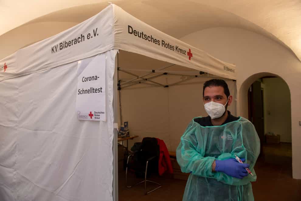 A Red Cross worker stands at a tent where he conducts rapid Covid-19 tests in Biberach in Germany (Stefan Puchner/dpa via AP)