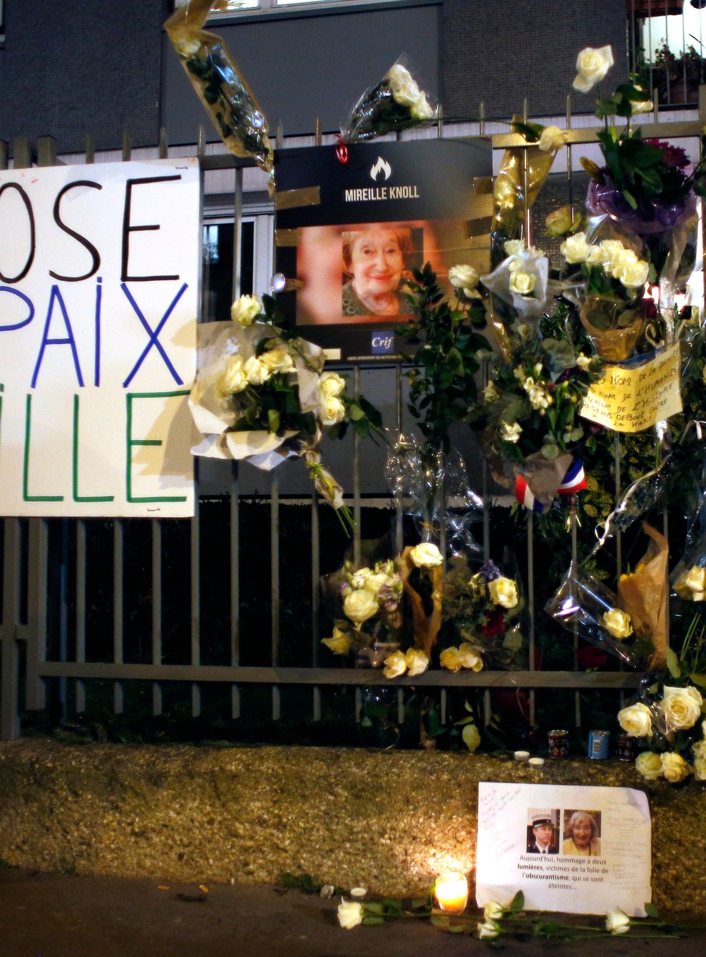 Flowers and placards outside Mireille Knoll’s Paris apartment (Thibault Camus/AP)
