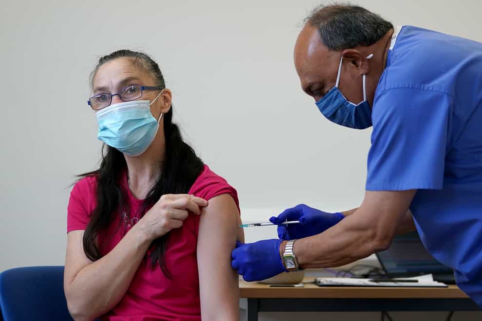 Doctor Abhi Mantgani gives a Covid-19 vaccine booster to Joanne Coombs at Birkenhead Medical Building in Merseyside (Martin Rickett/PA)