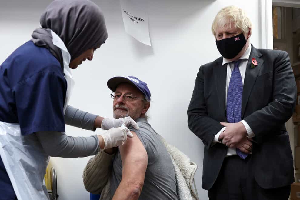 Prime Minister Boris Johnson watches a man receiving a coronavirus vaccination in a pharmacy in Sidcup, Kent (Henry Nicholls/PA)
