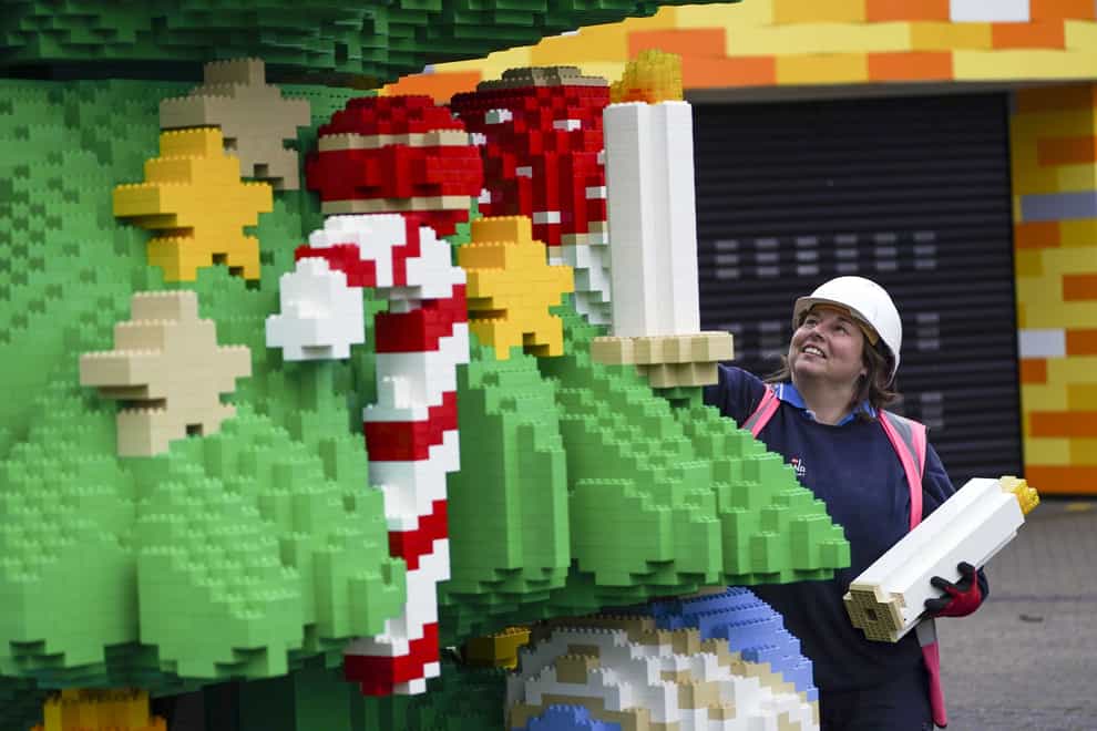 Chief model maker Paula Laughton puts the finishing touches to a 33ft tall Lego Christmas tree (Steve Parsons/PA)