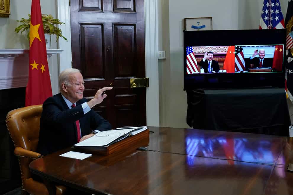 President Joe Biden waves as he meets virtually with Chinese President Xi Jinping (Susan Walsh/AP)