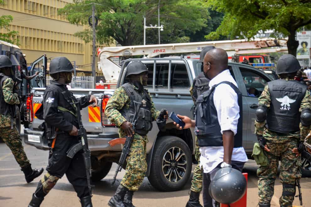 Security forces secure the scene of a blast on a street near the parliamentary building in Kampala, Uganda, Tuesday, Nov. 16, 2021. Two loud explosions rocked Uganda’s capital, Kampala, early Tuesday, sparking chaos and confusion as people fled what is widely believed to be coordinated attacks. (AP Photo/Ronald Kabuubi)