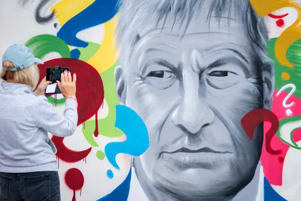 A person takes a photograph of ‘Why’, a mural of Sir David Amess by local Artist Madmanity, at a skate park in Leigh-on-Sea, Essex. (Aaron Chown/PA)