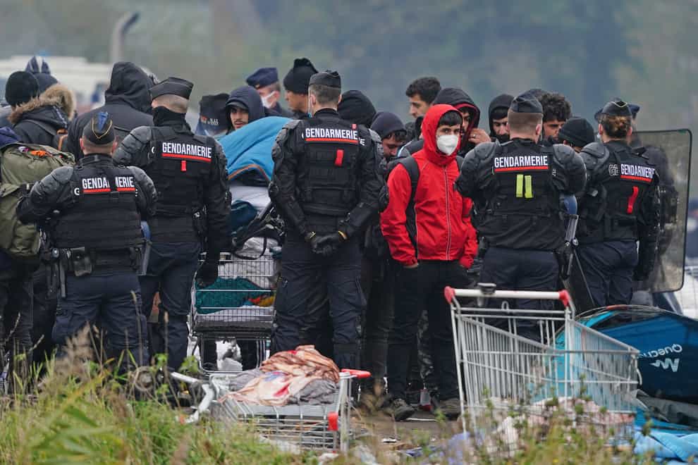 Migrants at a makeshift camp on the site of a former industrial complex in Grande-Synthe, east of Dunkirk, as French police are evacuating migrants from the site, where at least 1,500 people had gathered in hopes of making it across the English Channel to Britain. Picture date: Tuesday November 16, 2021.